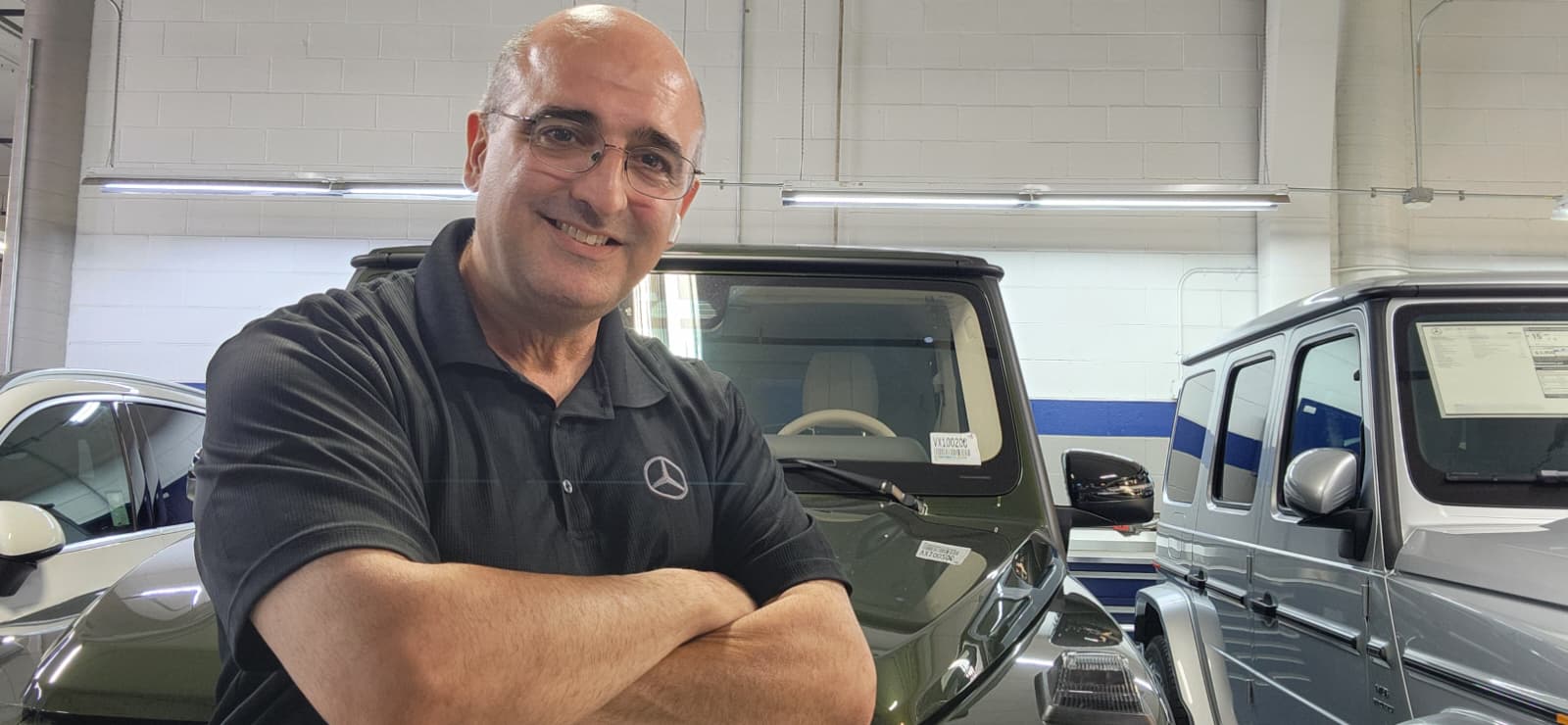 Al Mahmoudi standing beside Mercedes-Benz vehicles
